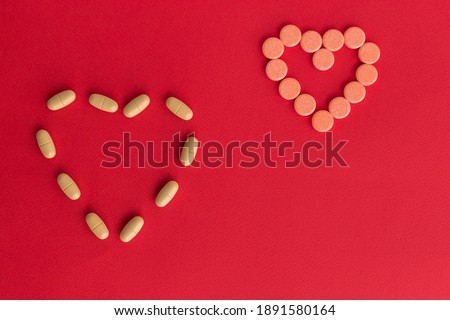 Heart shape from heart pills, Heart shaped pills on a red background. Medicines that help people. Concept of love pills, potency, loneliness, heart disease.