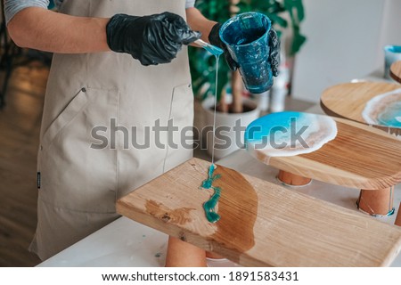 The art process of pouring epoxy resin into a wooden tray Royalty-Free Stock Photo #1891583431