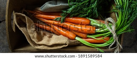 Fresh carrots on rustic kitchen with canvas bag in rustic wooden box. Flat lay, top view. Fresh organic vegetables carrots, freshly picked carrots with leaves Royalty-Free Stock Photo #1891589584