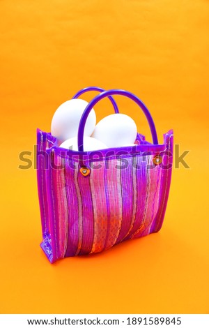 Bag to go to the market, sent or super Mexican style, with white eggs inside, on an orange background
