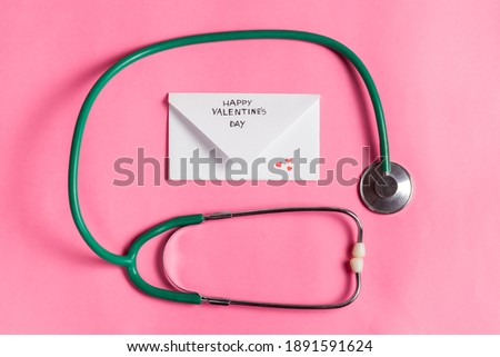Valentine's day medical flat lay. Stethoscope with Happy Valentine's day envelope. Medical Valentine's day greeting concept. Image for medicine, pharmacy, hospitals. 