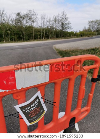 A gate closing a car park in England, United Kingdom. There is a sign on the barrier explaining that this is due to Coronavirus restrictions (Covid-19 lockdown)