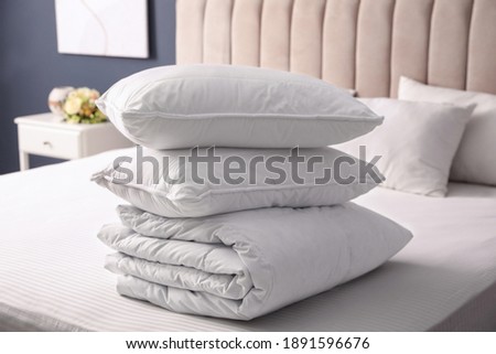 Soft folded blanket and pillows on bed indoors Royalty-Free Stock Photo #1891596676