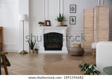 Elegant artificial fireplace in room. Interior design