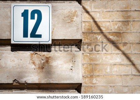 Number 12 on textured concrete wall