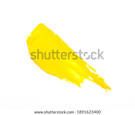yellow smear of oil paint on a white background. traces of yellow paint