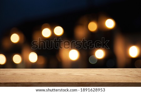 empty table on dark background with blurred lamps, cafe restaurant bokeh for your product or customization