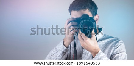 young photographer man hand holding camera