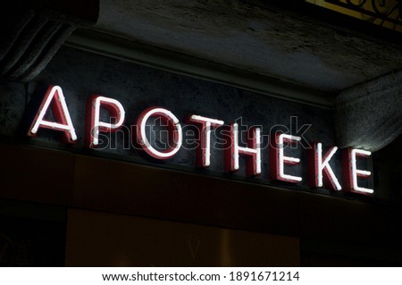 Luminous Apotheke (english translation of drugstore) neon inscription hanging on a pharmacy store in Lugano, Switzerland