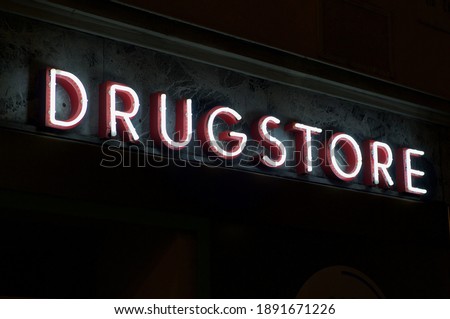 Luminous Drugstore neon inscription hanging on a building of a pharmacy in Lugano, Switzerland