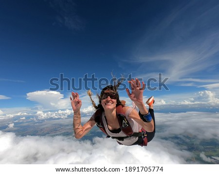 Young woman parachutist smiling in free fall. Perfect concept of happiness and freedom. Royalty-Free Stock Photo #1891705774