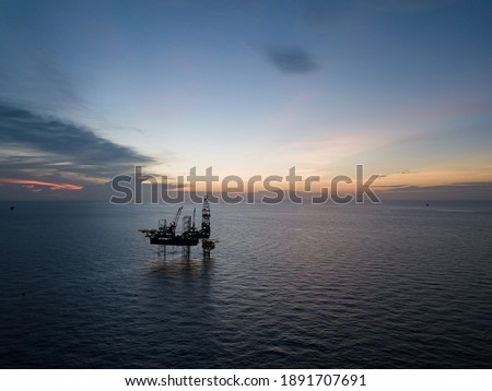 Aerial view offshore drilling rig (jack up rig) at the offshore location during sunset Royalty-Free Stock Photo #1891707691