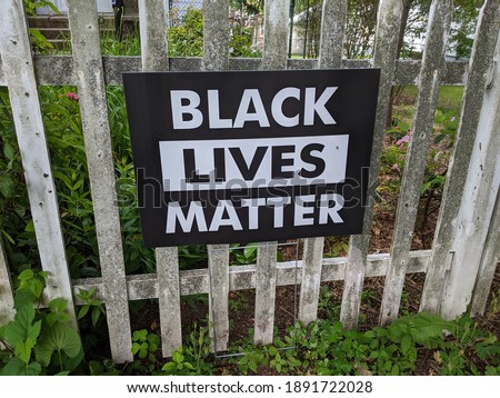 Black Lives Matter Sign On A Wood Gate In Front Of A House