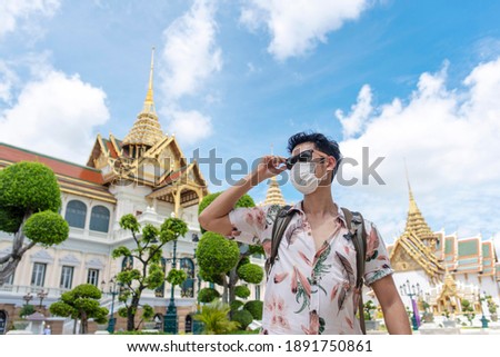 An Asian man wearing mask and sunglass travelling in the Royal Grand Palace in Bangkok during the pandemic Covid-19 Royalty-Free Stock Photo #1891750861