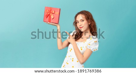 Beautiful elegant young asian woman in summer dress holding gift box