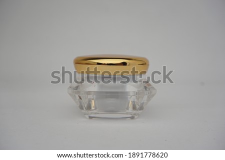 Glass container packaging photo with luxurious gold lid, suitable for cosmetic and pharmaceutical industries
