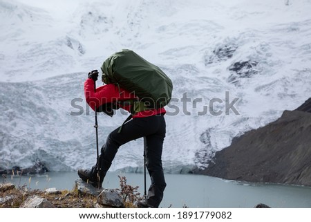 Exhausted woman backpacker hiking in high altitude winter mountains Royalty-Free Stock Photo #1891779082