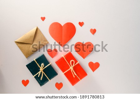 Valentine's Day background. Gifts, candle, confetti, envelope on pastel white background. Valentines day concept. Flat lay, top view, copy space