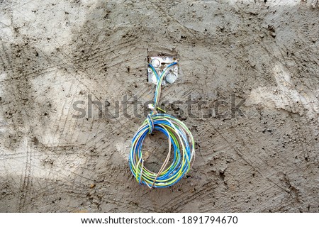 Freshly laid concrete wall with wet scratches and colored electrical cables,, abstract background, texture. Stock Photo.