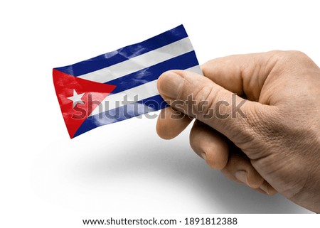 Hand holding a card with a national flag the Cuba