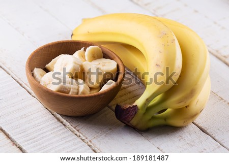 Sliced banana in bowl on white wooden background. Selective focus. Royalty-Free Stock Photo #189181487