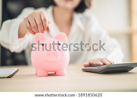 woman putting coins in a piggy bank,
Financial planning and money saving concept. Royalty-Free Stock Photo #1891850620