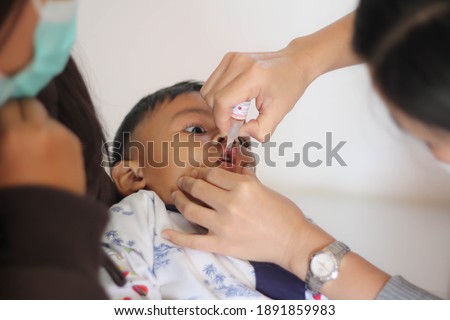 Nurse making infant oral vaccination against rotavirus infection. Children health care and disease prevention. Royalty-Free Stock Photo #1891859983