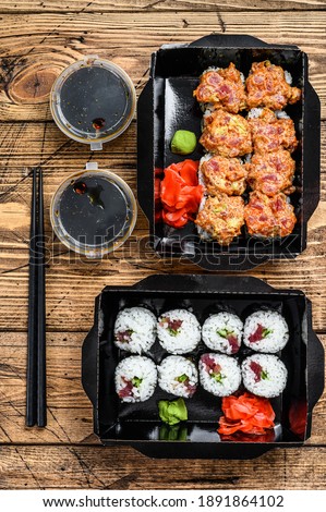 Japanese restaurant food in take away, set delivery box. Wooden background. Top view.