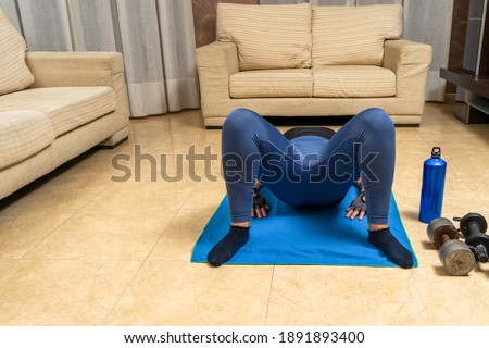 Middle-aged woman with sportswear in low shape exercising in her living room. Healthy life concept