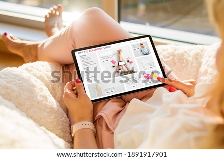Woman using tablet and shopping online on boutique fashion store