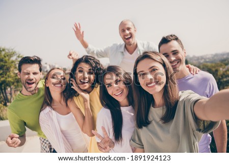 Photo group of young smiling excited cheerful positive good mood people partying chill on rooftop take selfie outside