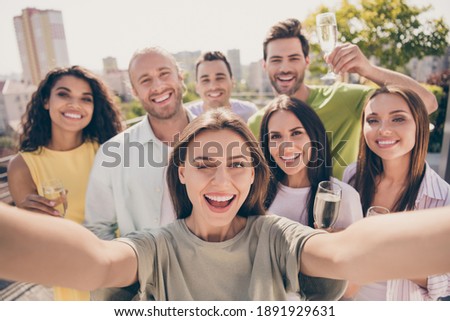 Photo portrait of young students company at party in university campus taking selfie smiling drinking champagne winking outdoors