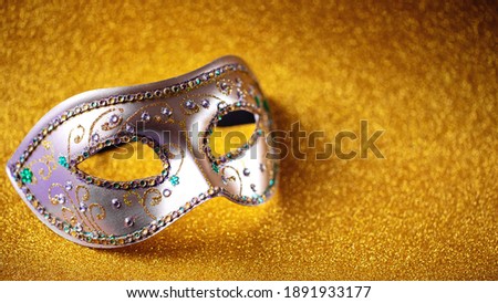 Festive, colorful Mardi Gras or carnivale mask on golden background. Venetian masks. Party invitation, greeting card, venetian carnivale celebration concept.