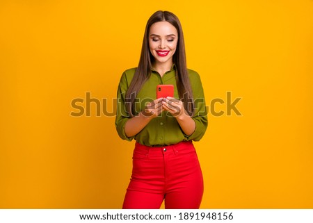 Portrait of attractive cheerful straight-haired girl using digital device 5g browsing web isolated over bright yellow color background