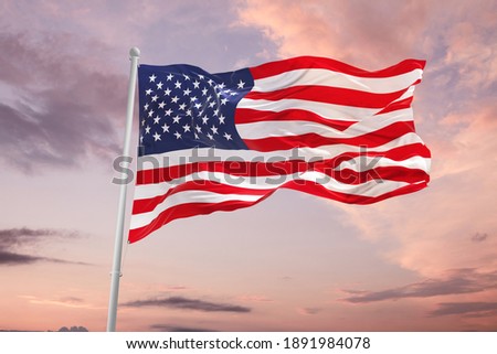 Flag of United States of America being waved in the breeze against a sunset sky.. US flag Royalty-Free Stock Photo #1891984078