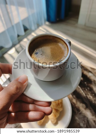 Mobile point of view image of woman holding modern smartphone and taking pictures of her morning breakfast coffee and tasty croissants buns to share photos on social media resources