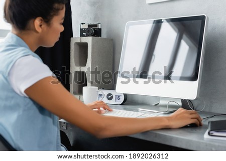 young african american freelancer working on laptop at home, blurred foreground