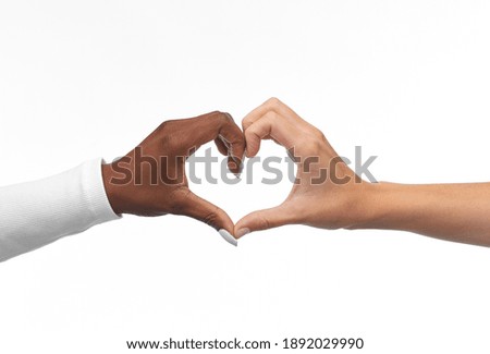 love, valentines day and friendship concept - black and white hands making heart gesture