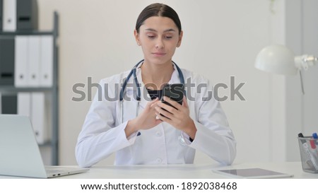 Female Doctor using Smartphone at Clinic