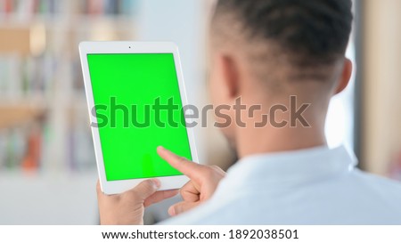 African Man using Tablet with Green Chroma Key Screen, Rear View 