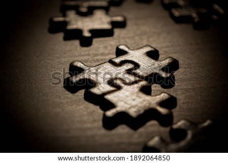 Close up piece of  jigsaw puzzle as a concept of business success in challenge completion with teamwork.Jigsaw puzzle on the black table. Royalty-Free Stock Photo #1892064850