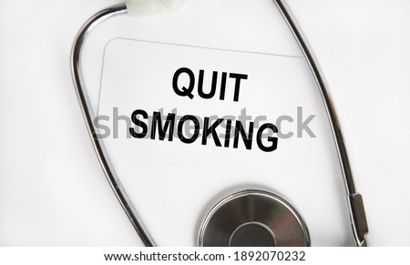 On the business card, the text of zuIT SMOKING, next to the stethoscope.
