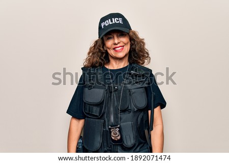 Middle age beautiful policewoman wearing bulletproof uniform and cap over white background with a happy and cool smile on face. Lucky person. Royalty-Free Stock Photo #1892071474