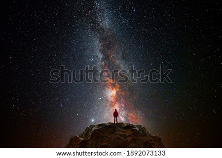 Man on top of a mountain observing the universe Royalty-Free Stock Photo #1892073133