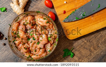 Raw marinated chicken meat with garlic, ginger and teriyaki sauce in a glass bowl on wooden table Royalty-Free Stock Photo #1892093515