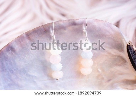 Faceted morganite stone beads silver earrings on pearl shell background