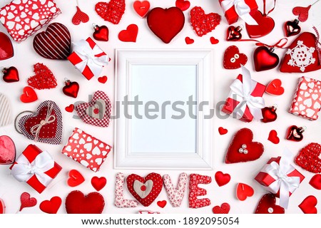 Mock up photo frame with hearts and gifts on white background for valentines day concept. Top view with copy space.