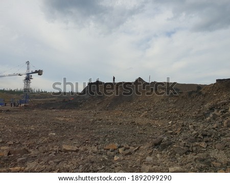 A construction site in the north among the forest. Construction equipment work. Dump truck, bulldozer, truck at work.