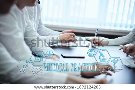 A group of doctors in a modern clinic is planned. The concept of modern medicine and medical biotenology. Medical icons on the screen with the inscription: MEDICAL PRACTICE