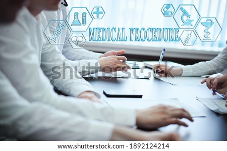A group of doctors in a modern clinic is planned. The concept of modern medicine and medical biotenology. Medical icons on the screen with the inscription: MEDICAL PROCEDURE